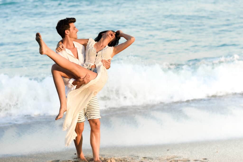 Young happy couple walking in a beautiful beach
